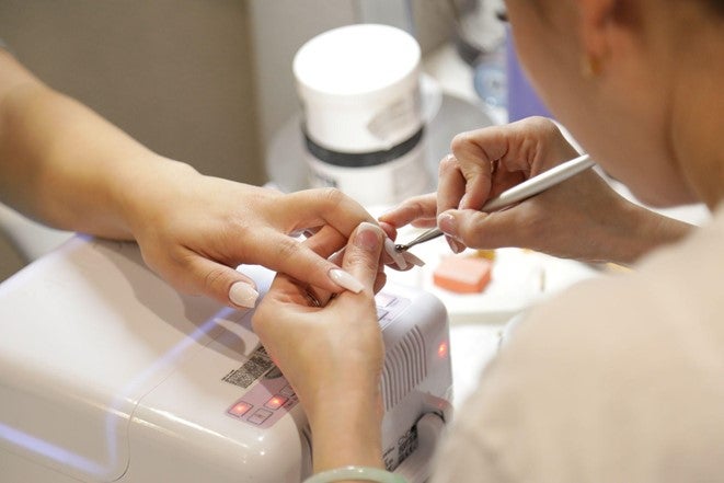 A beautician polishes the nails of a client in a Bristol nail bar