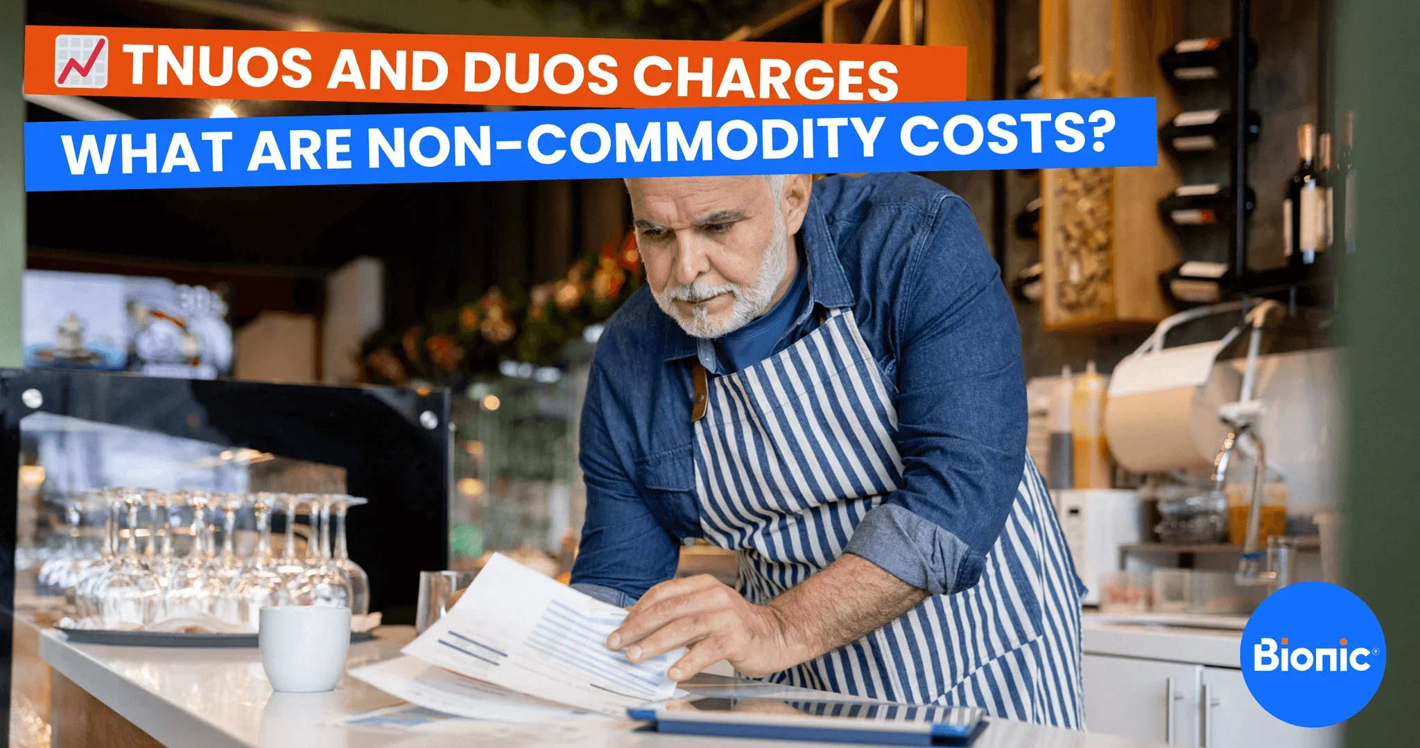 A business owner stands in his cafe with a calculator trying to work out his energy bills. The caption reads: TNUoS and DUoS charges - what are non-commodity costs?