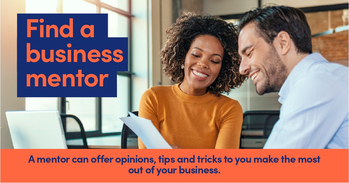 Woman in orange jumper being a business mentor to a man in a blue shirt