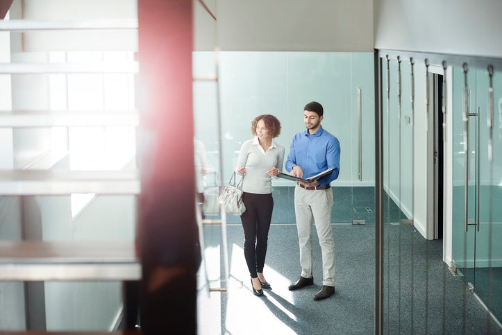 A business owner is being shown around some empty office space by a real estate agent.