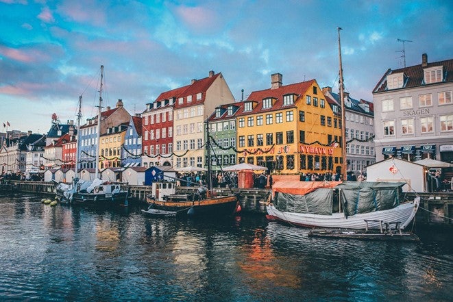 Multi-coloured houses by the water at sunrise in Copenhagen, Denmark.