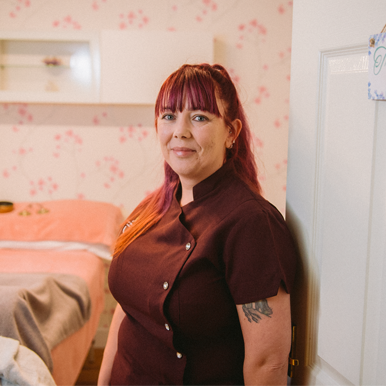 Alison from New Moon Holistic Therapies stands in the doorway of her treatment room