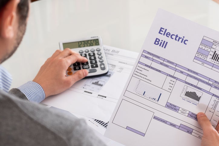 A business owner works out what his electric bill will be when government support ends
