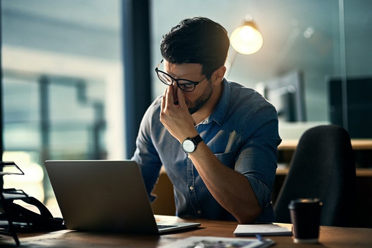 businessman experiencing stress and burn out during a late night while working from home