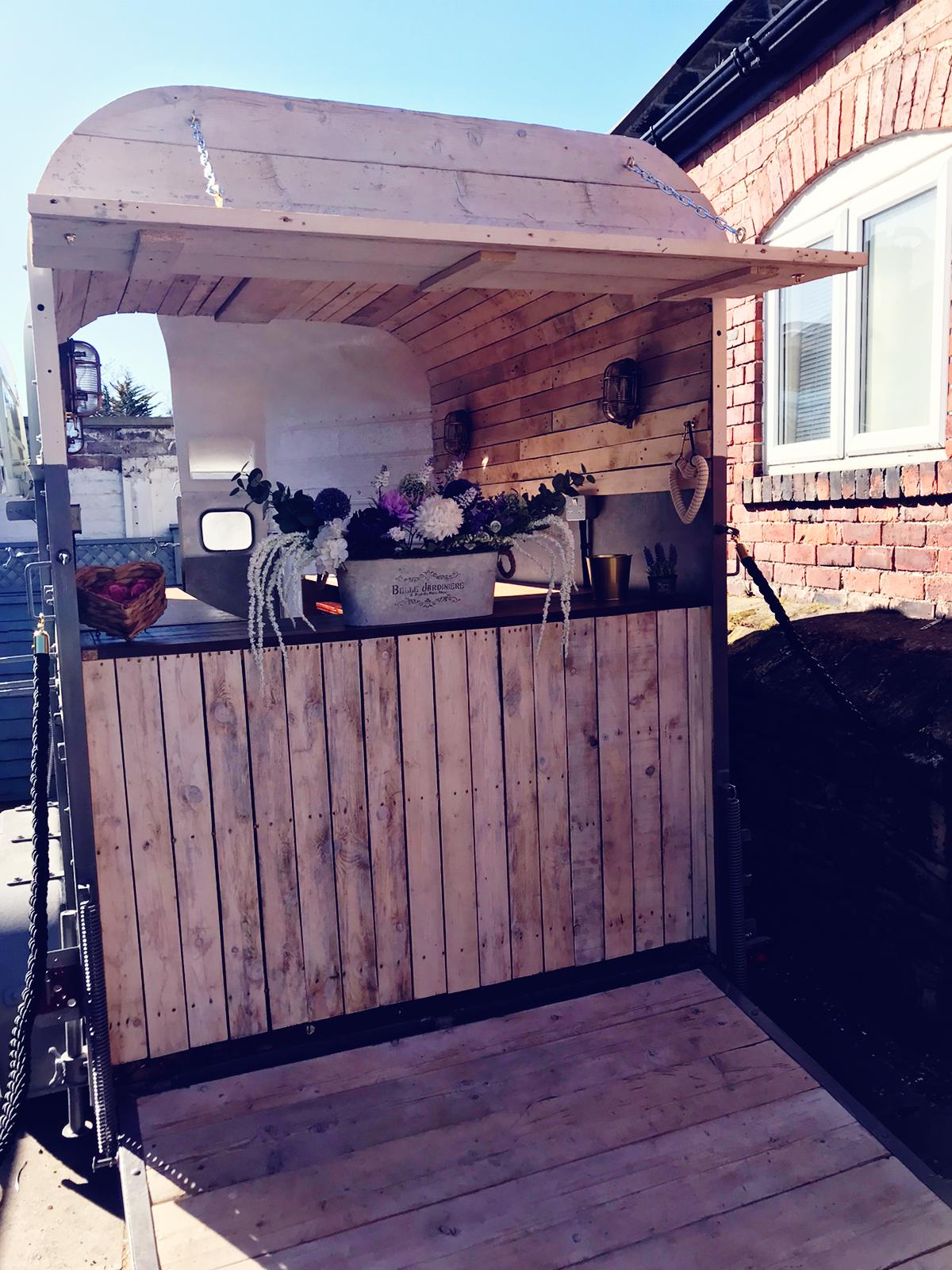 A wooden bar area with a bucket of flowers and a heart-shaped bowl of fruit