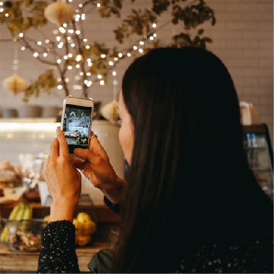 Business owner in shop checking Instagram social media account on her phone.