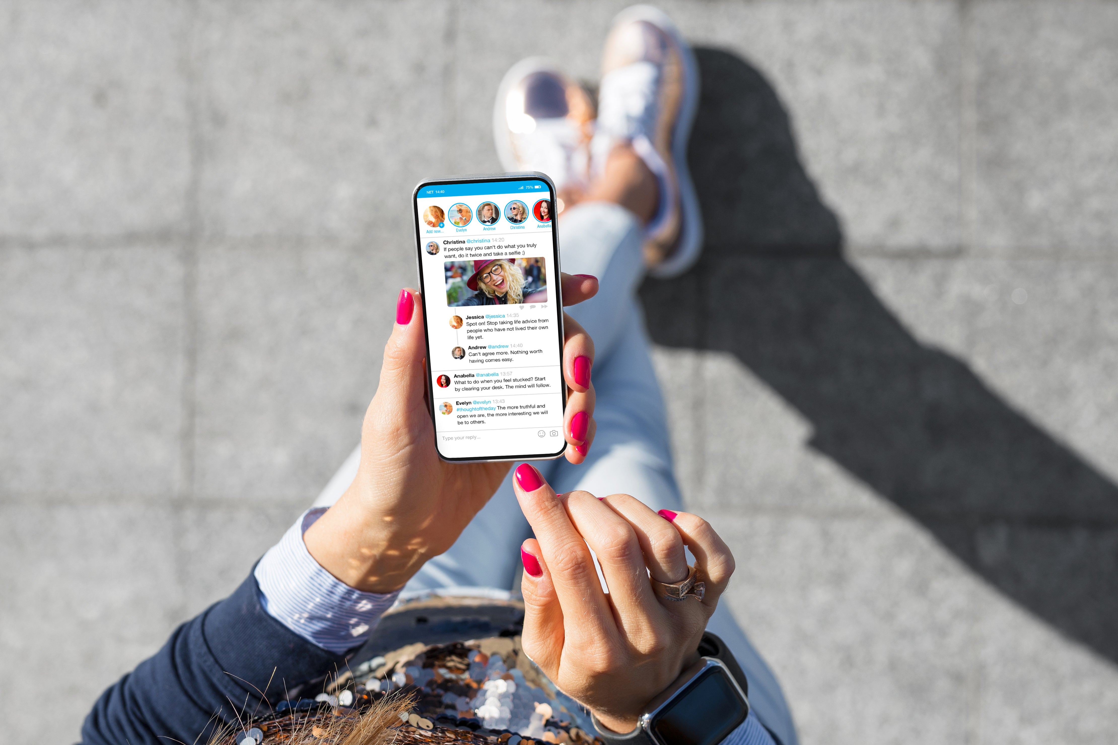 A hand with pink painted nails holding a phone and swiping through social media