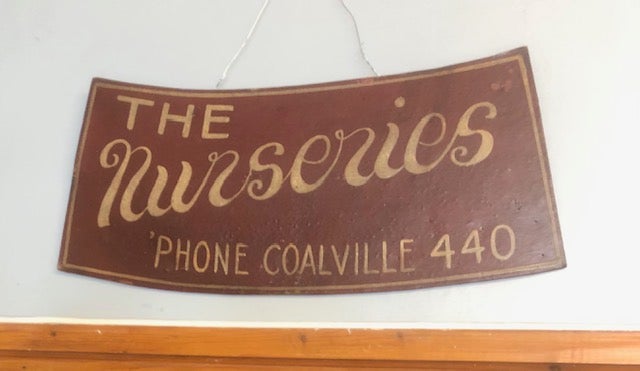 Old burgundy sign with The Nurseries Phone Coalville 44 in gold lettering