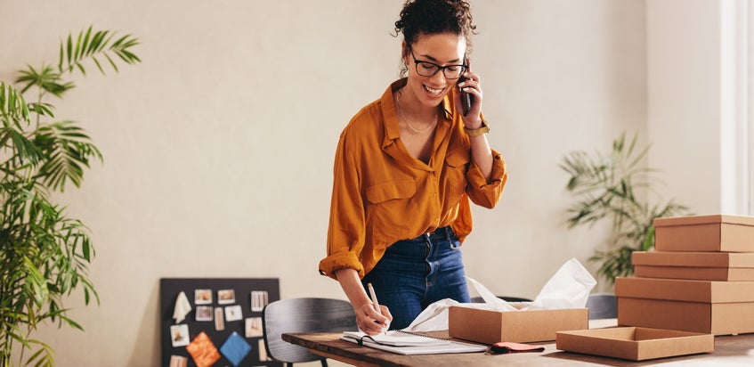 Small business owner talking on mobile phone to arrange a business grant for her startup.