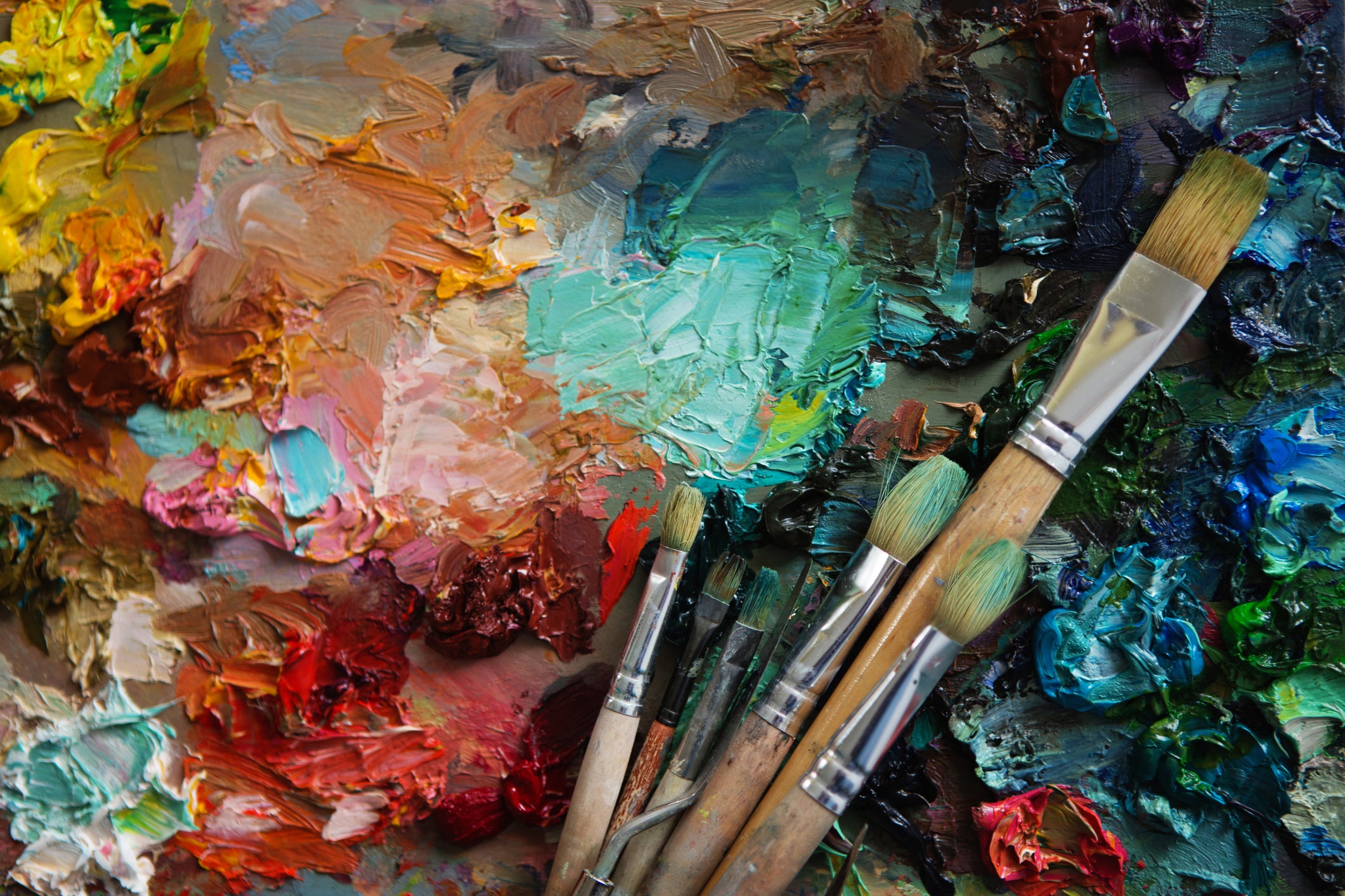 Paintbrushes on a background of multicoloured oil paint