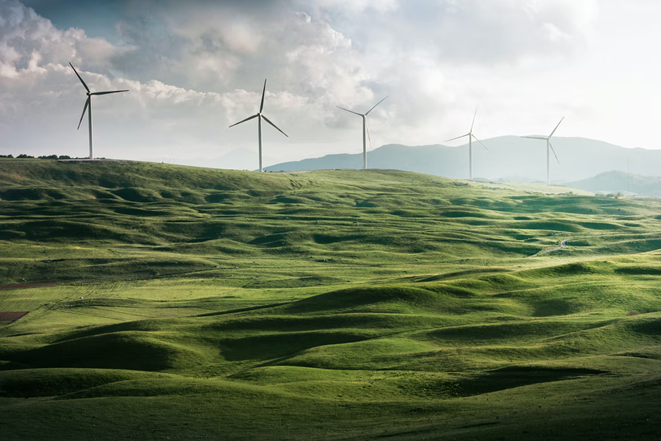 An onshore windfarm on rolling green hills in England.