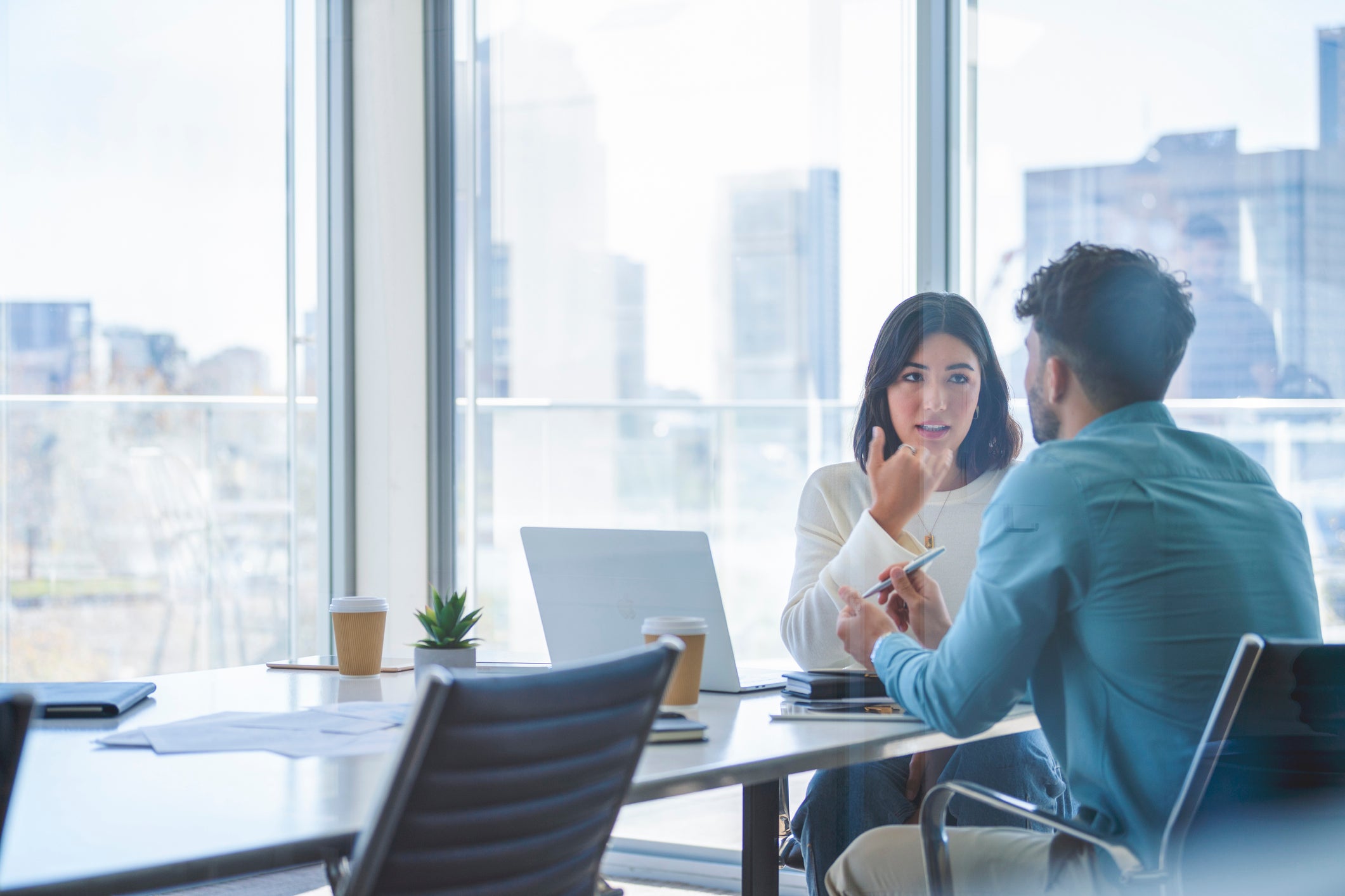 Two people talk to each other during a meeting in an office about a dismissal