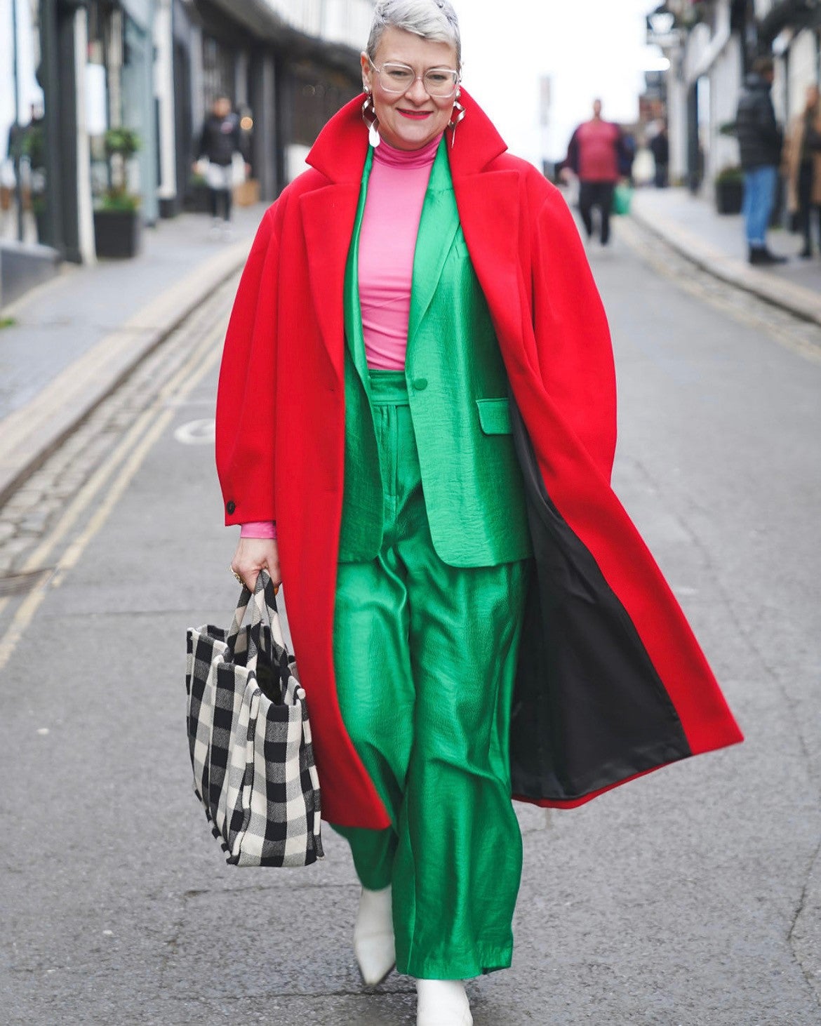 Abbey models a vibrant green suit with a bright red coat