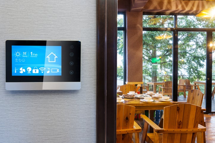 A smart thermostat with a screen on the wall of a restaurant in a hotel business