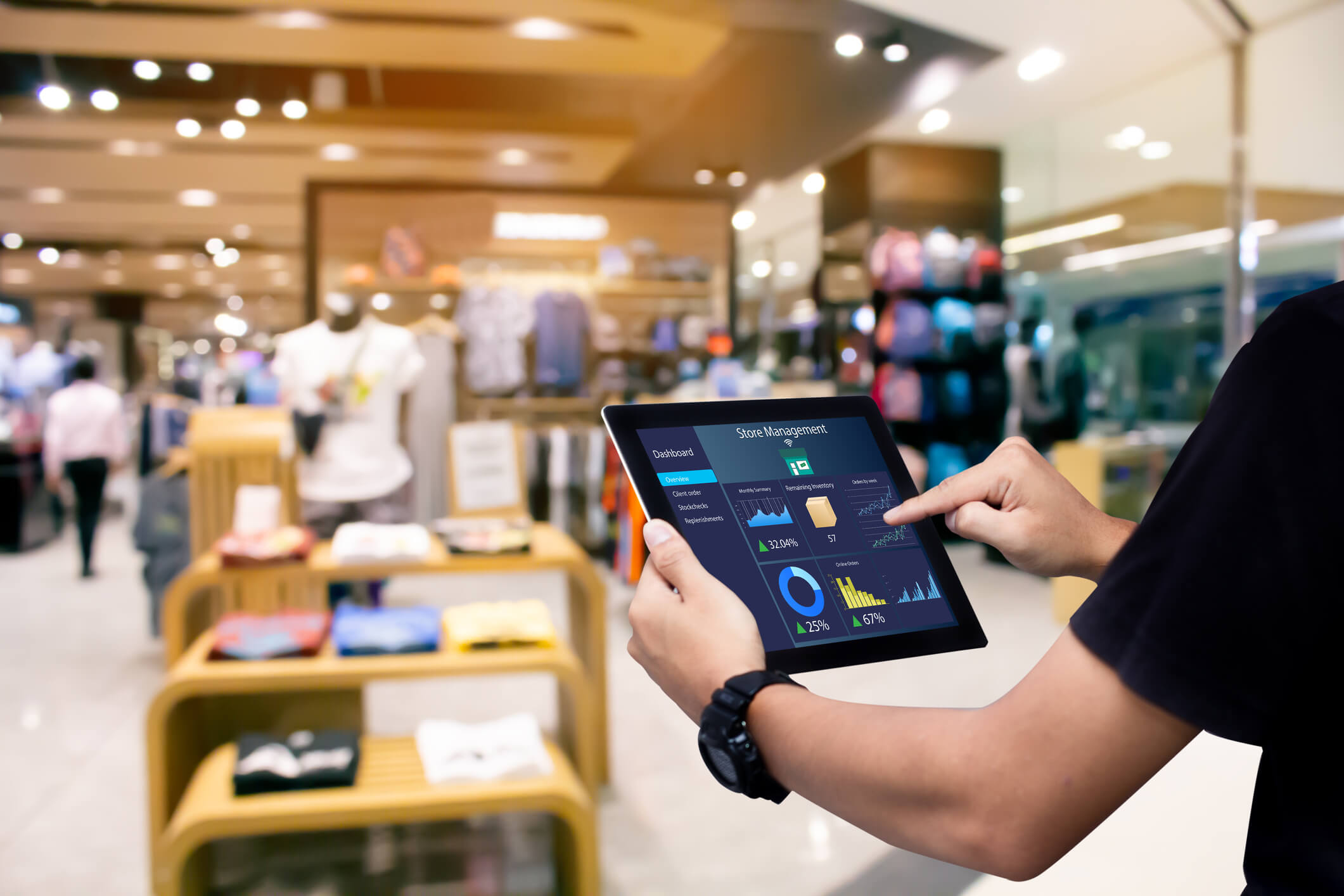 A business owner connects to WiFi in his store to carry put an inventory on clothing he sells using a tablet computer