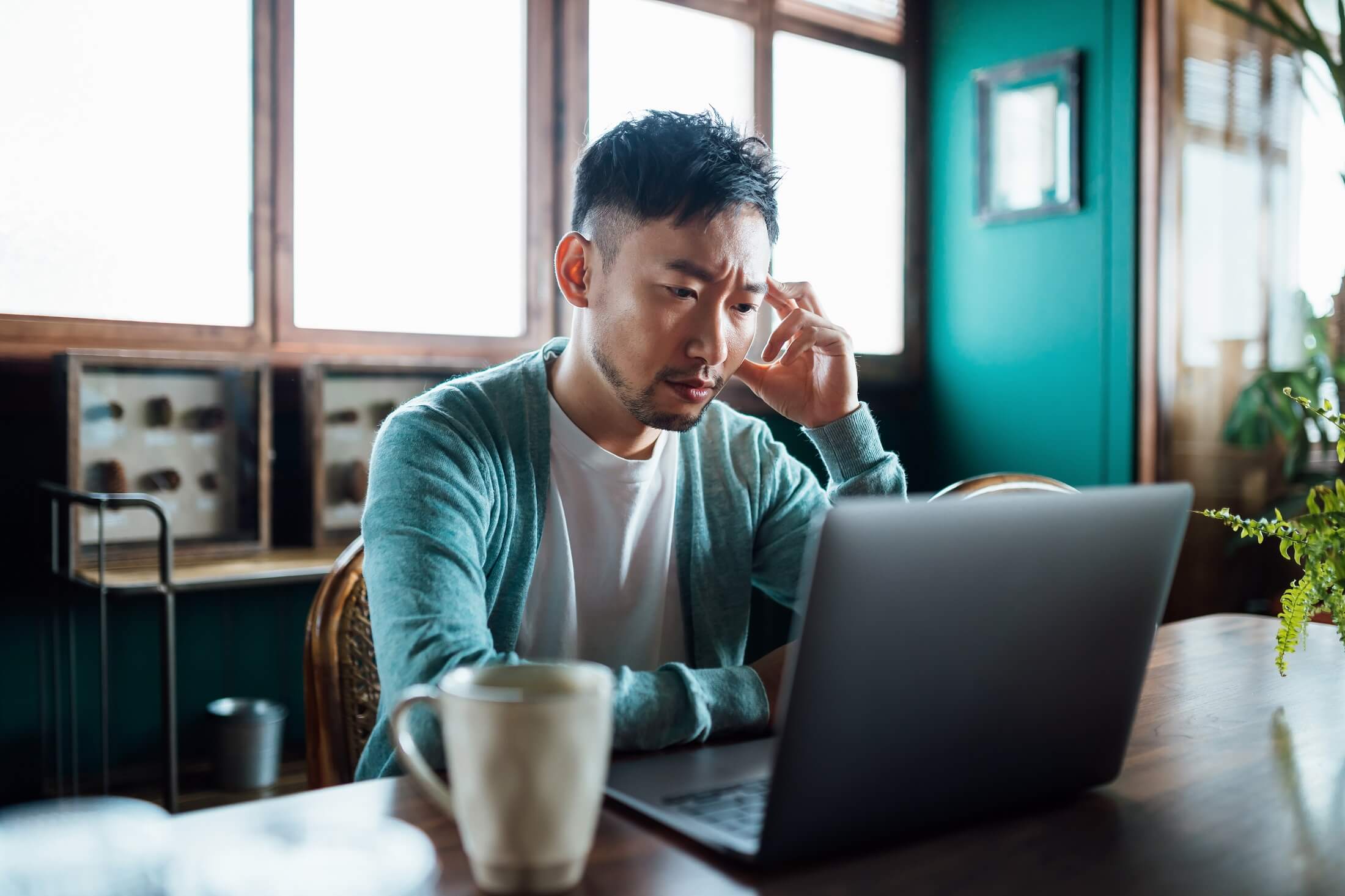 A business owner looks concerned as he researches ransomware 