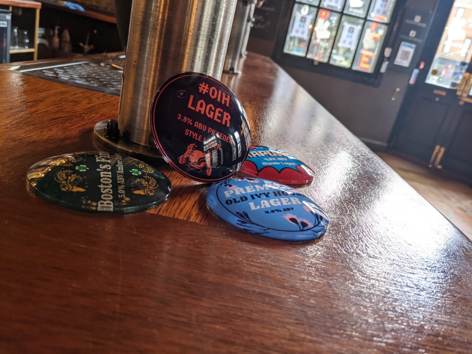 Old beer mats by a beer pump in The Old Ivy House