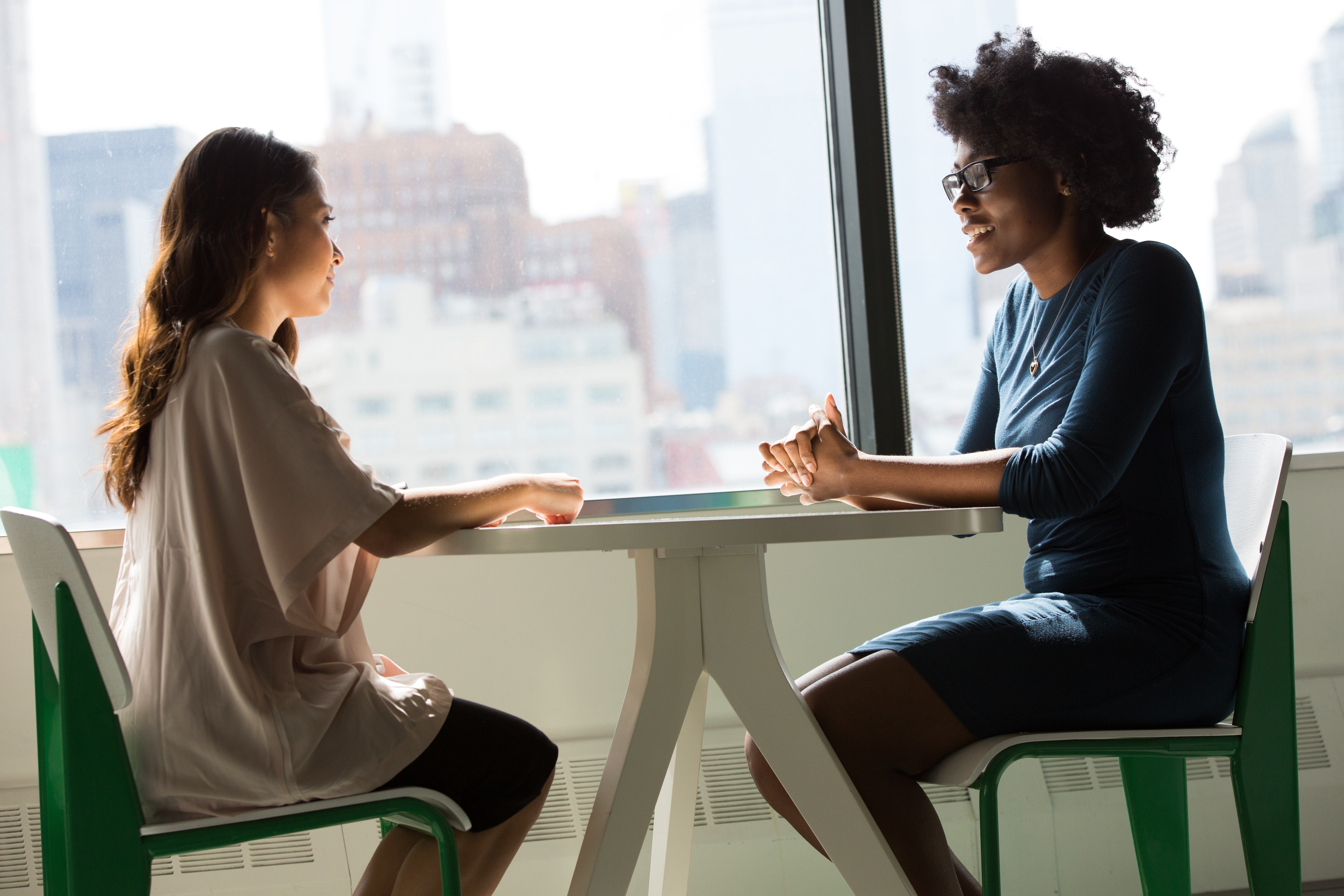 Two people seated at a table talking