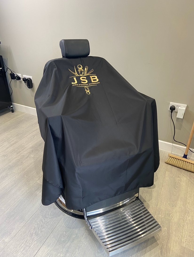 Jamie's client chair with a black hairdressing cape over it