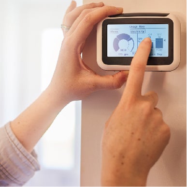 Hands holding up smart meter after new business energy meter installation