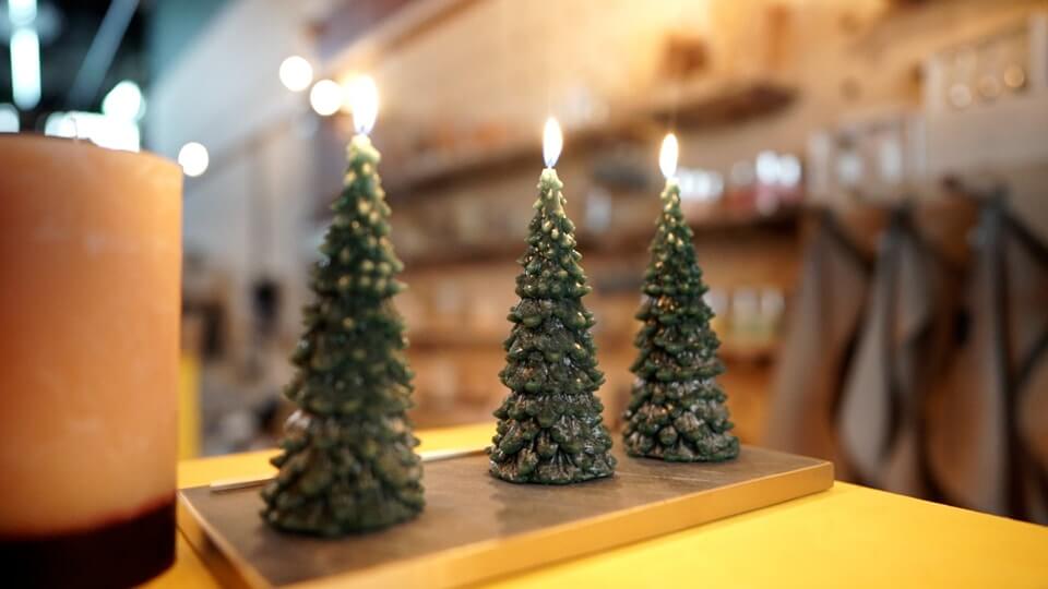 Three green Christmas tree candles glowing 