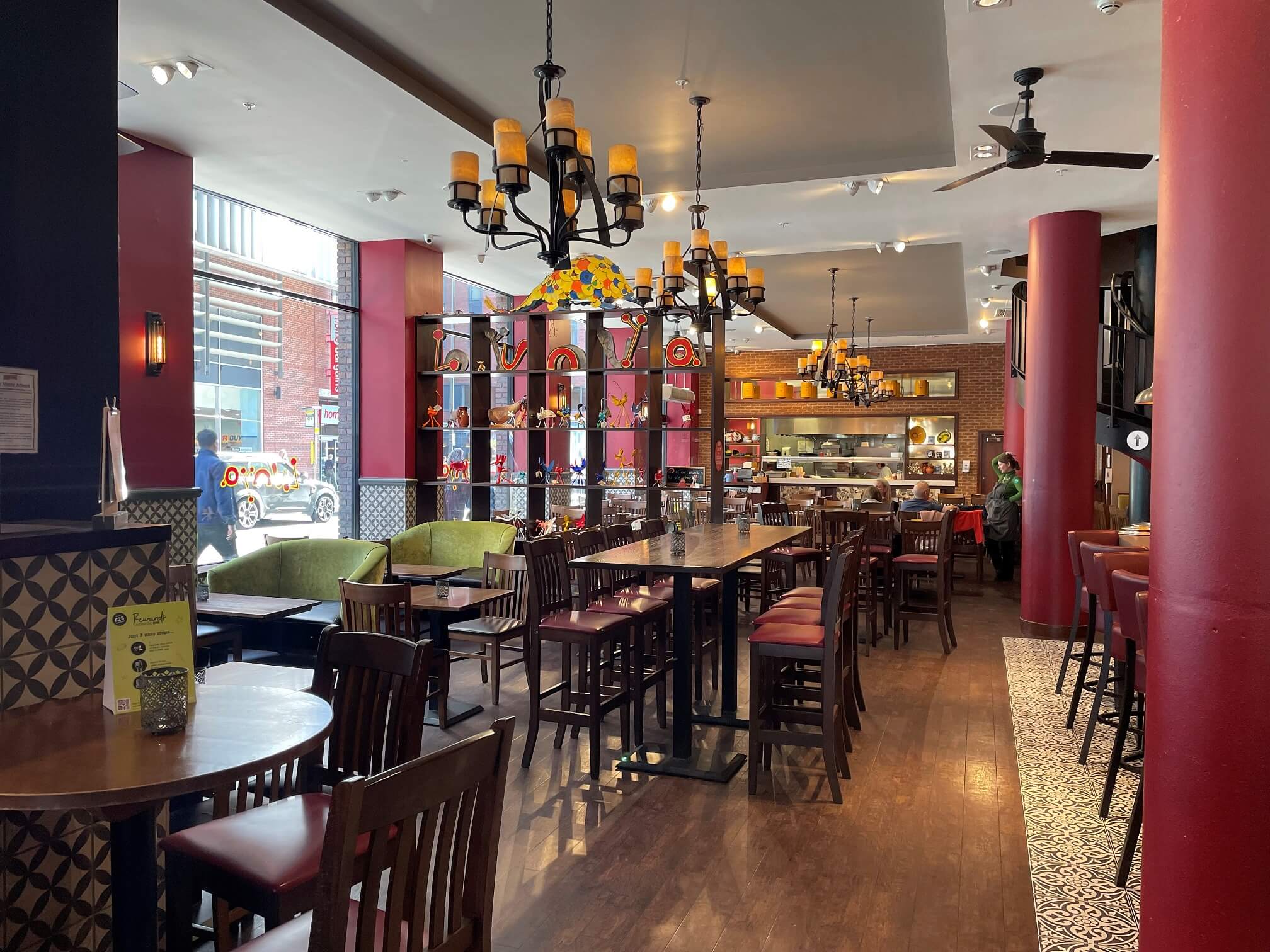 Interior of Lunya restaurant and deli, showing table and chairs and open kitchen in the background