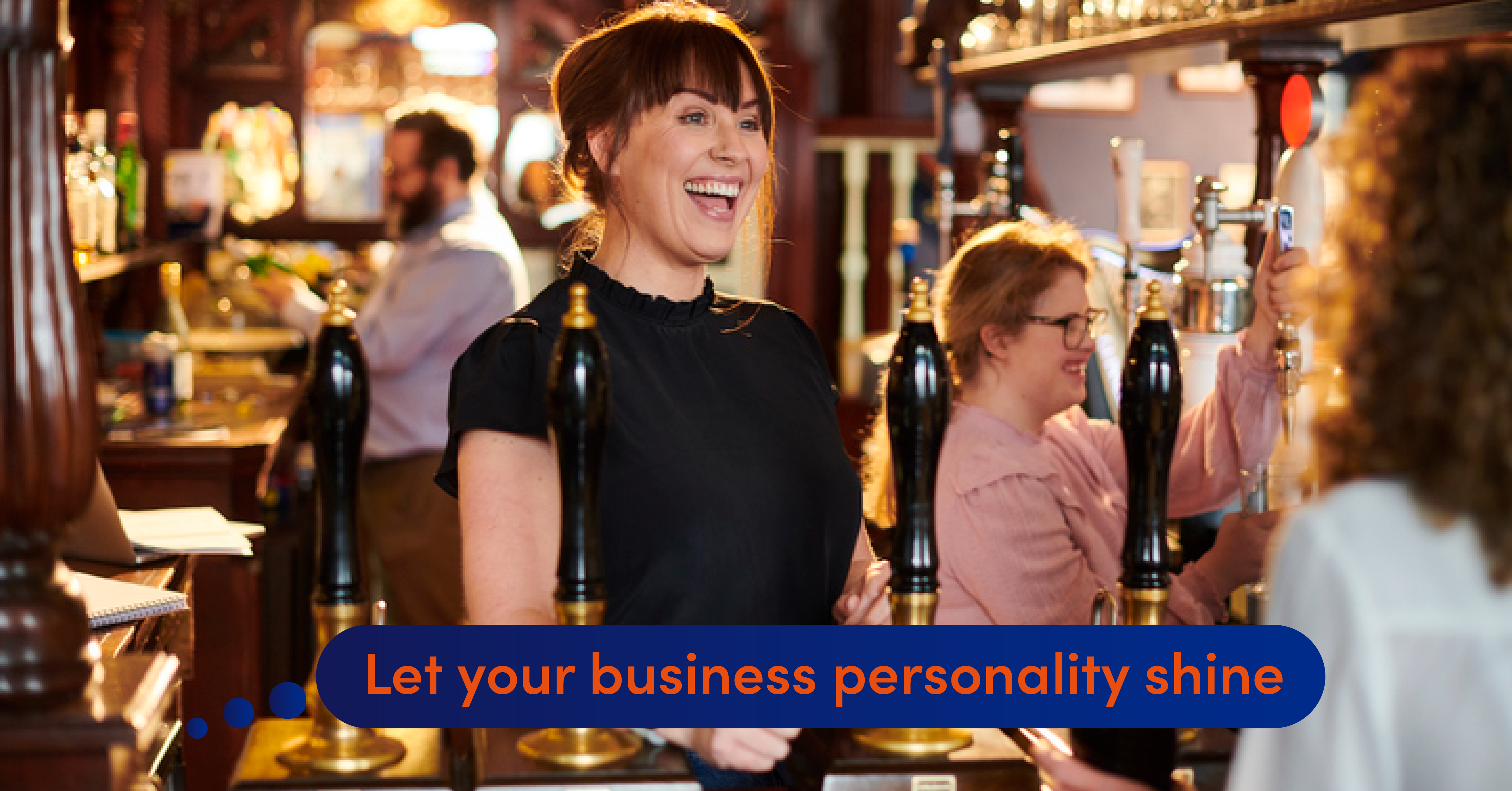 A pub owner stands behind the bar and smiles at customers while two other bar staff serve