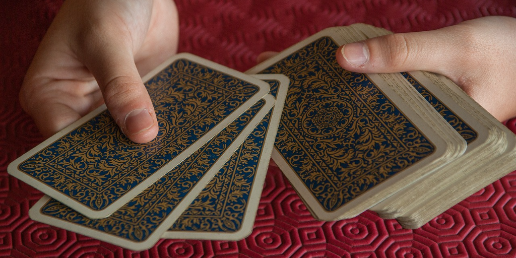 Hands holding a pack of tarot cards