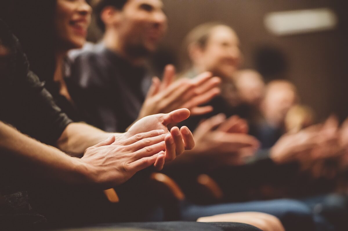 A closeup of a group of people clapping at a marketing event