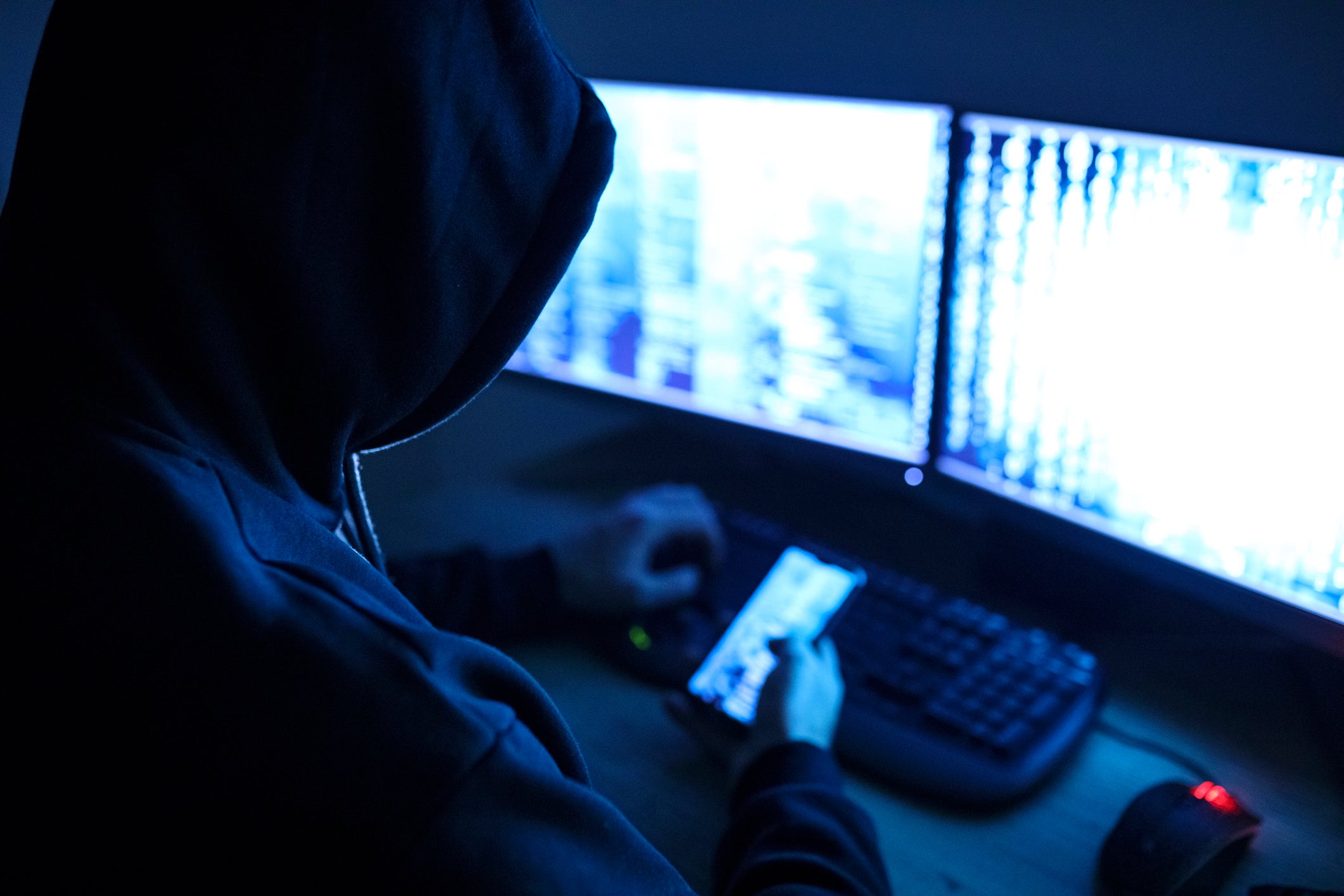 A hacker looks at a computer screen