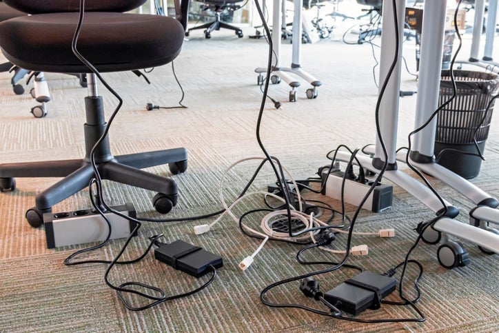 Office electricity cables. Unwound and tangled electrical wires under the table.