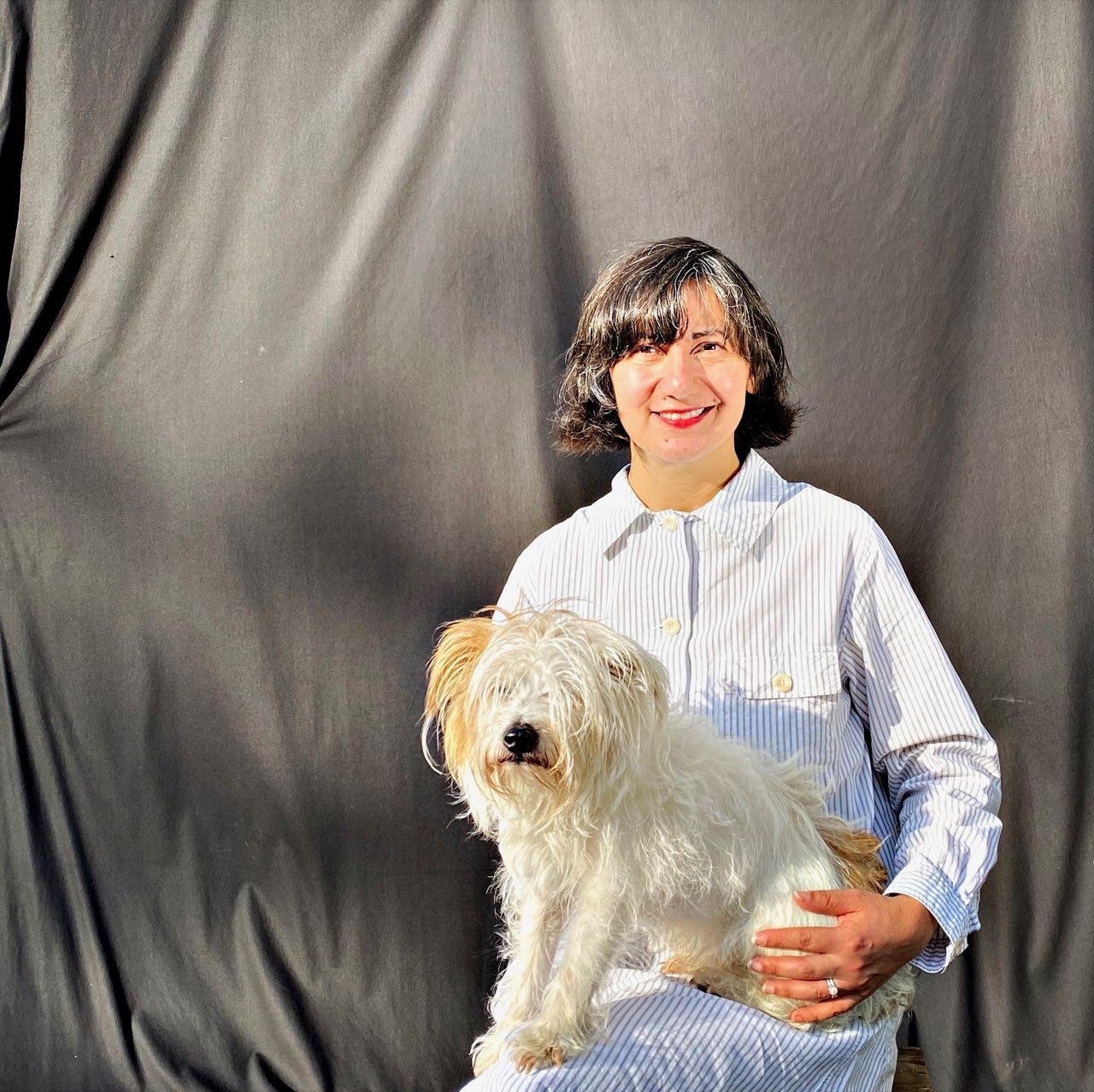 Owner Lilly holds a white dog smiling