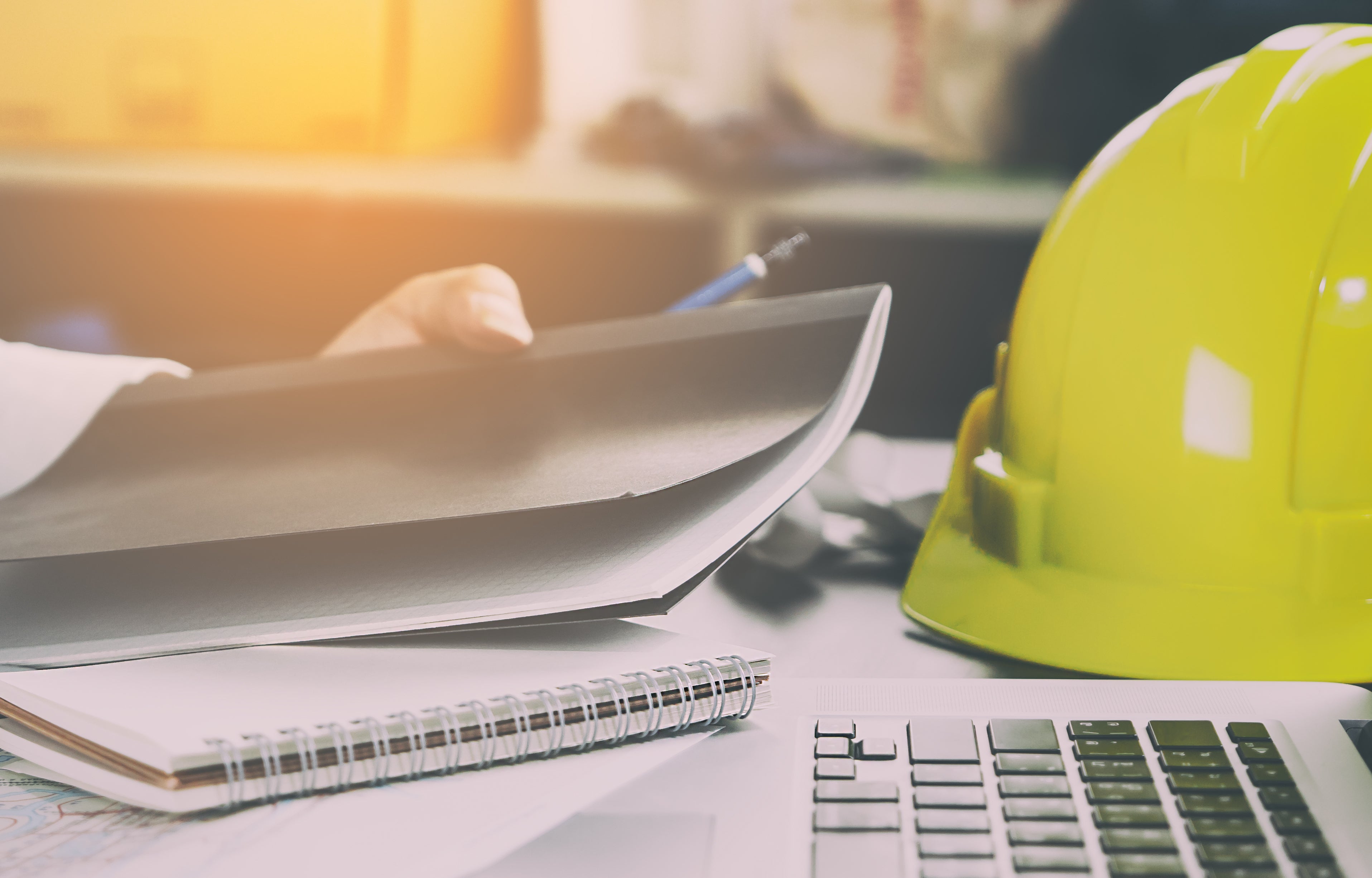 A hardhat and notebook to represent health and safety at work