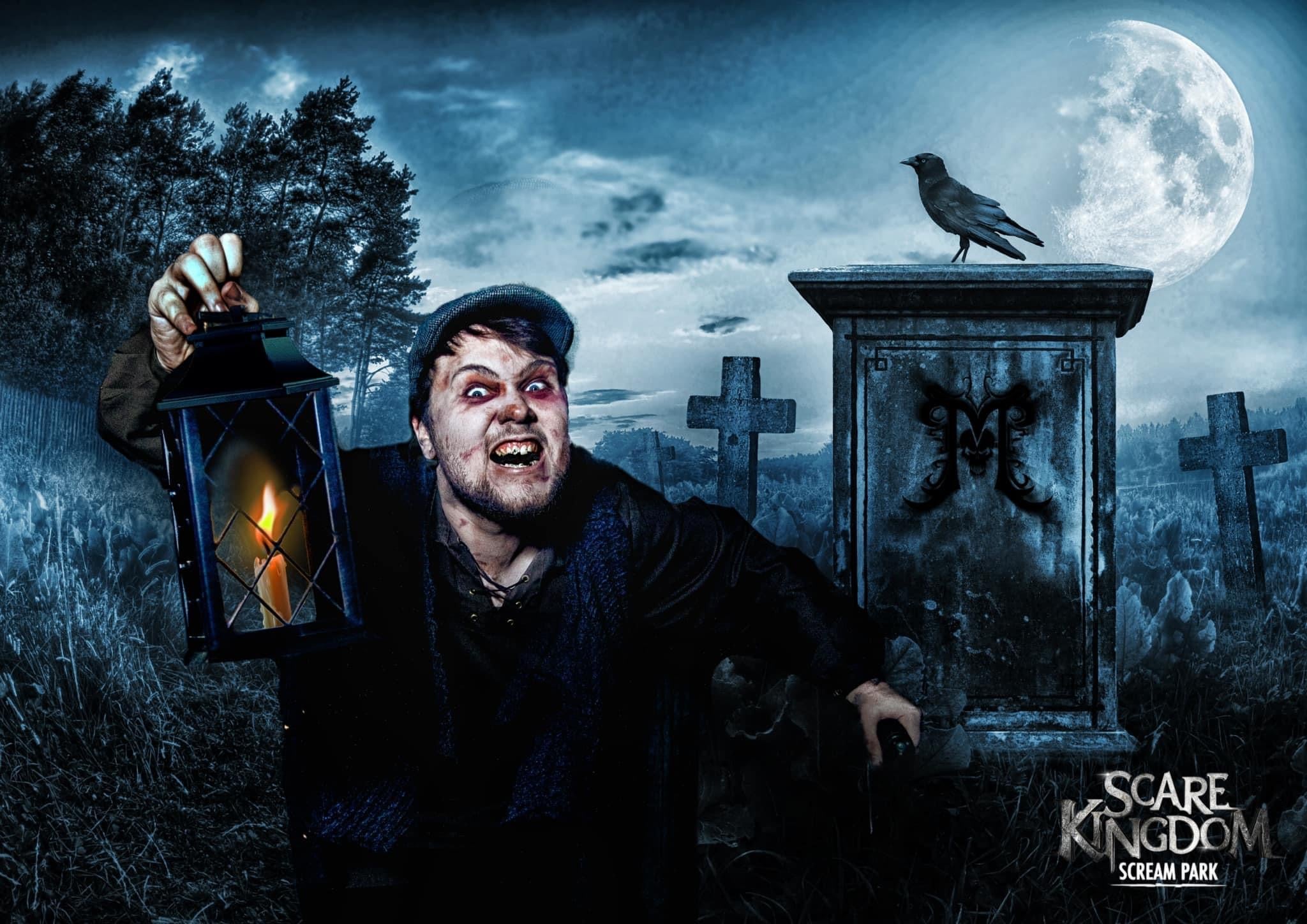 One of the scare maze actors dressed as a graveyard keeper holding a lantern in dim lighting 