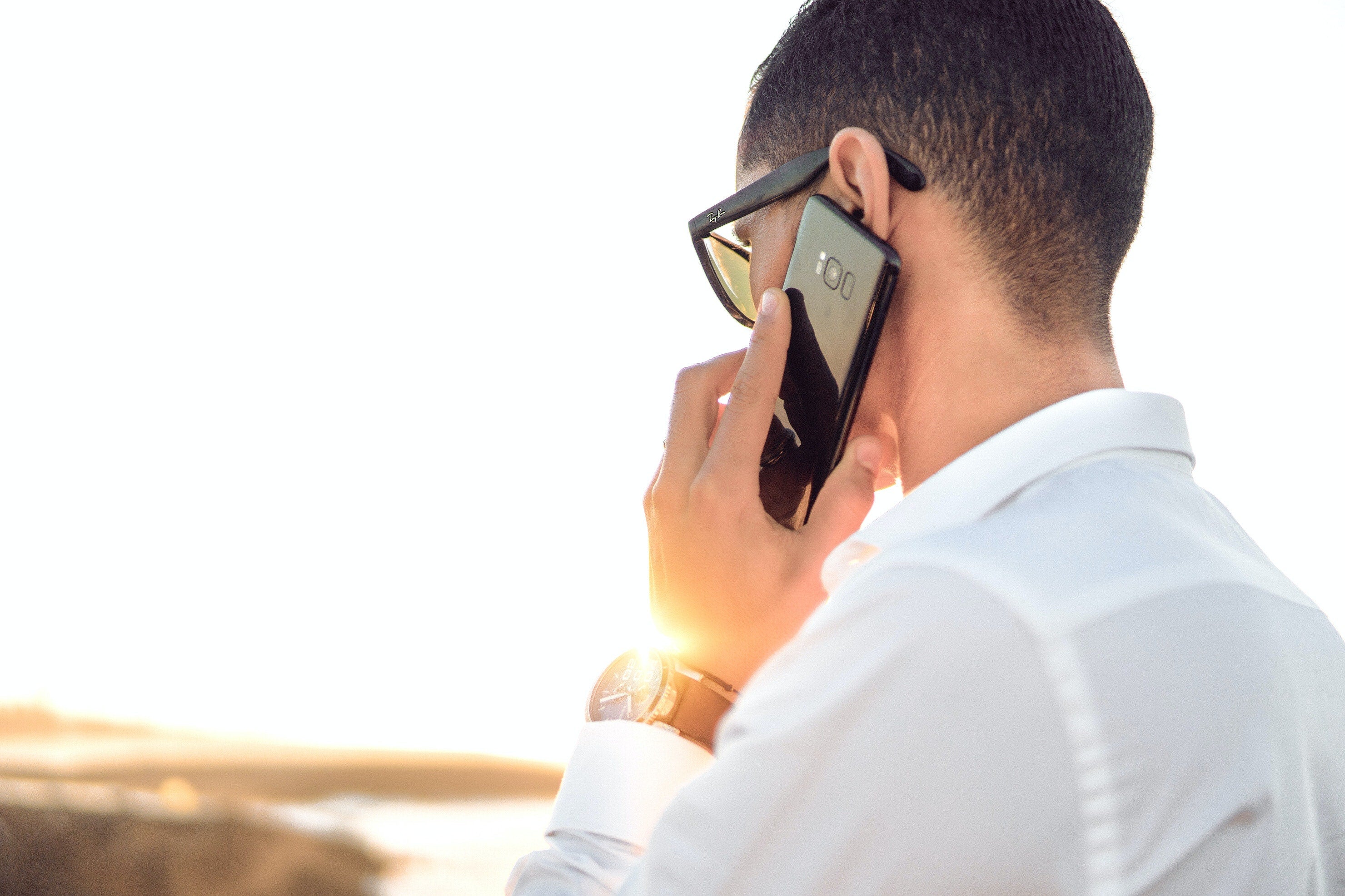 A man with his back to the camera on the phone