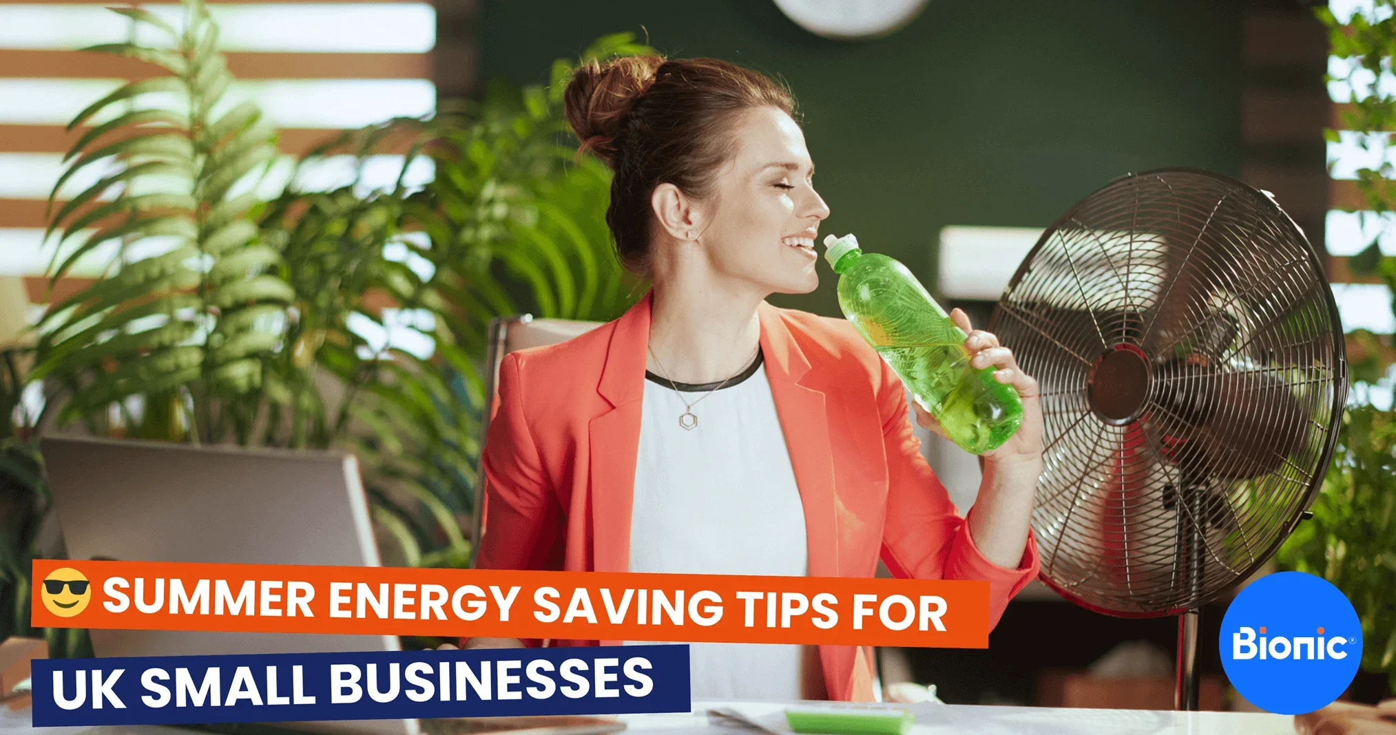 A female business owners sits at her desk by a fan and drinking from a bottle to keep cool during summer. The caption reads: Summer energy saving tips for UK small businesses
