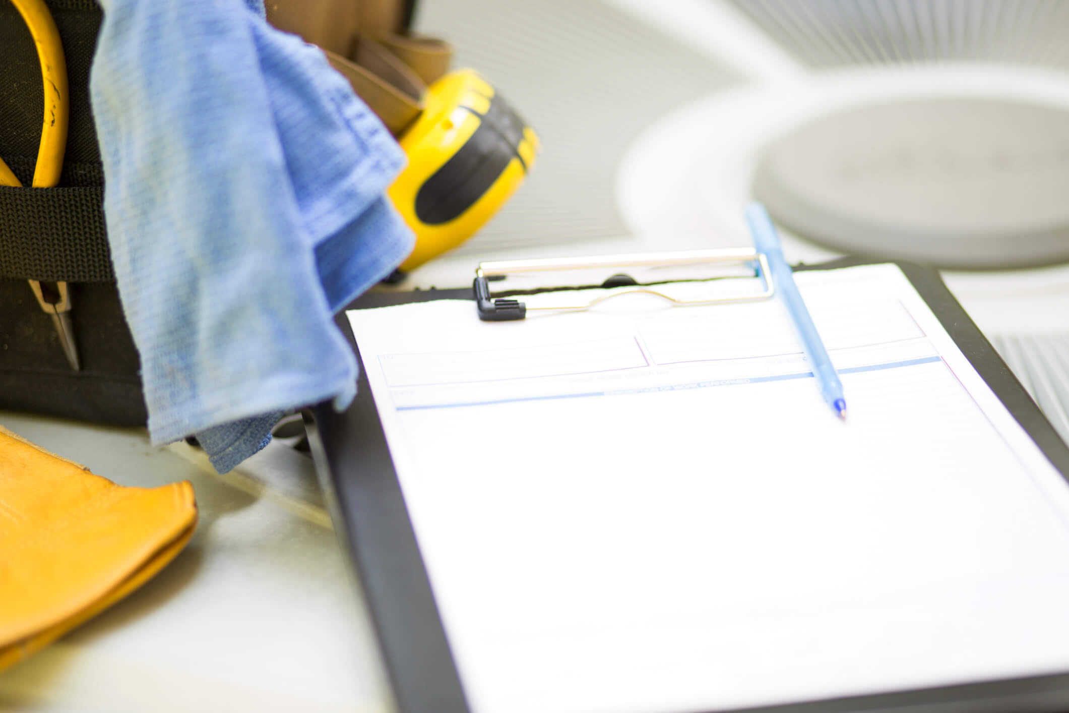 clipboard on top of a large fan with paper and a pen and workwear