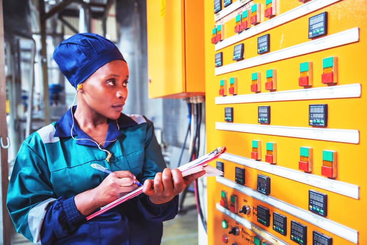 A factory worker checks multiple meter readings as part of an energy audit