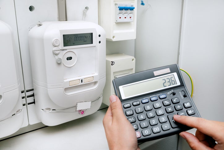 A business owner uses looks at their energy meter and uses a calculator to work out how much of an Energy Price Relief Scheme discount they will get