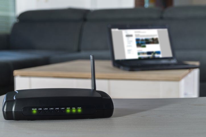 A home business internet connection. A wlan router on desk with notbook in background.