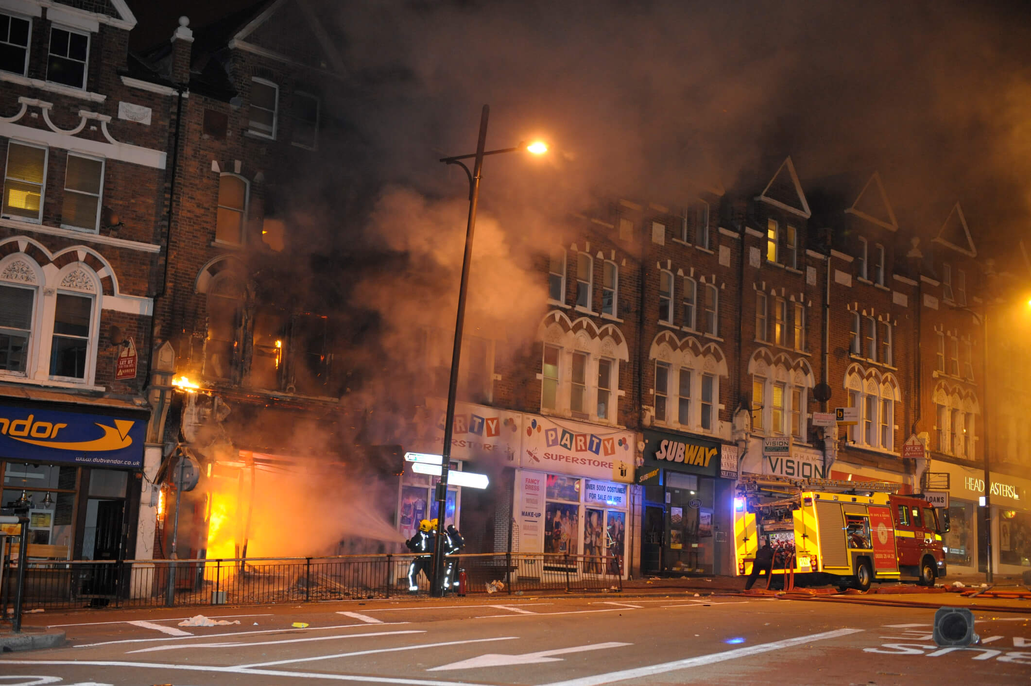 Firefighters tackle fire at Party Superstore on Lavender Hill, Clapham Junction after it was set alight by arsonists during riots.