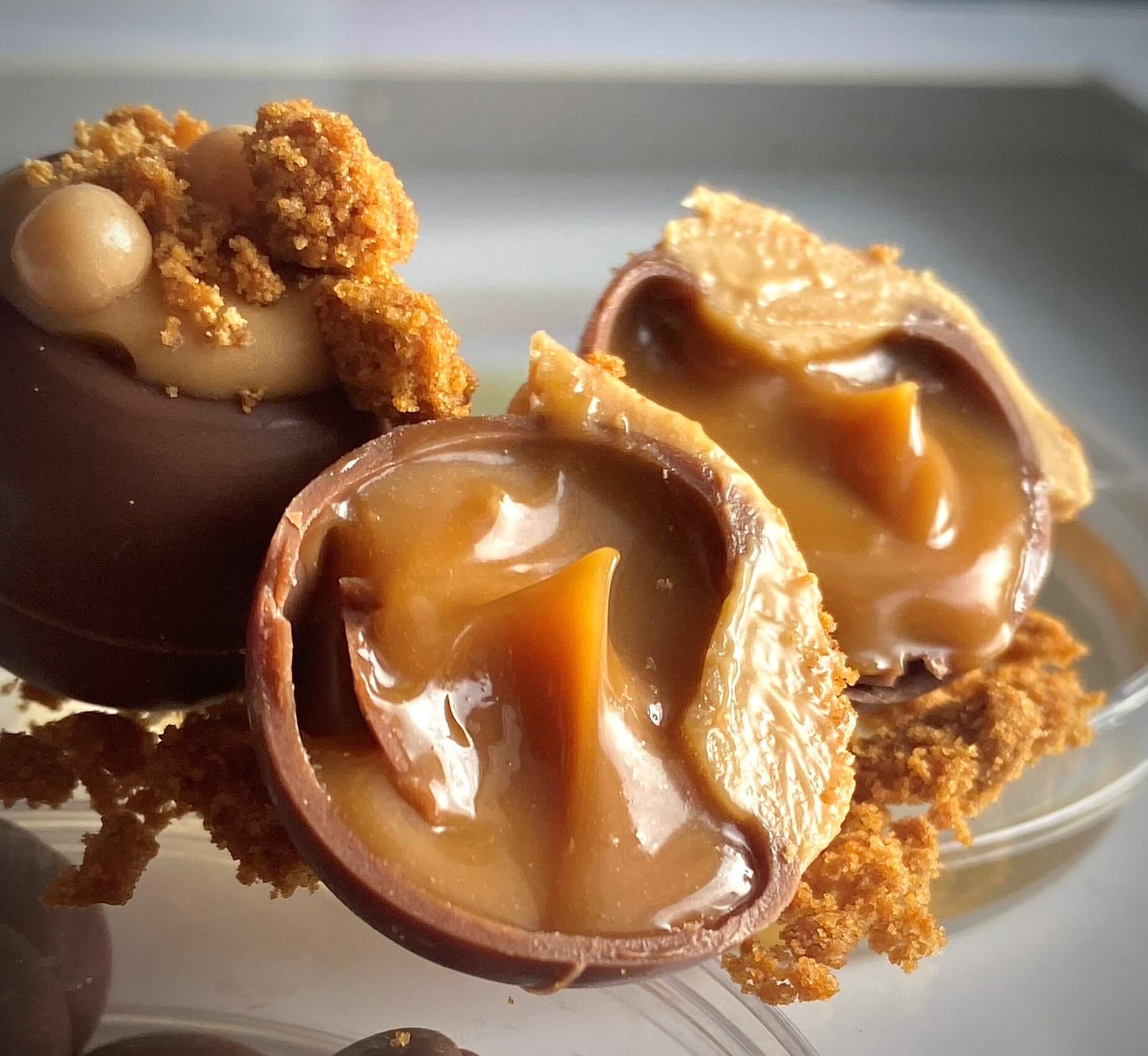 Caramel oozes out of a pile of freshly crafted chocolates.