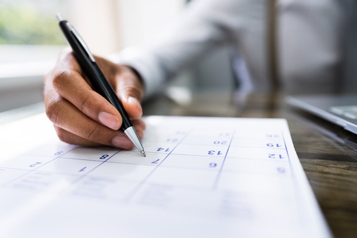 Young Man Holding Pen Marking Date in his calendar when his energy tariff ends