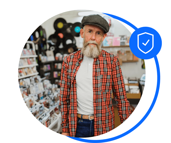 Elderly male record shop owner stood in front of records