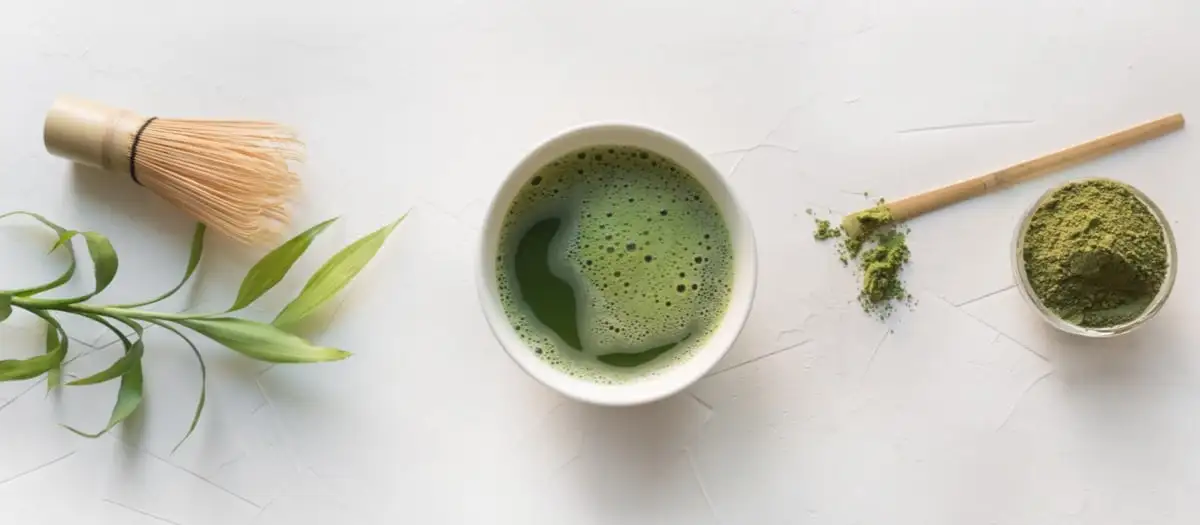 Eine Schüssel Matcha-Teepulver und eine Tasse mit Matcha-Tee