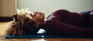 Frau liegt auf dem Boden und entspannt sich.