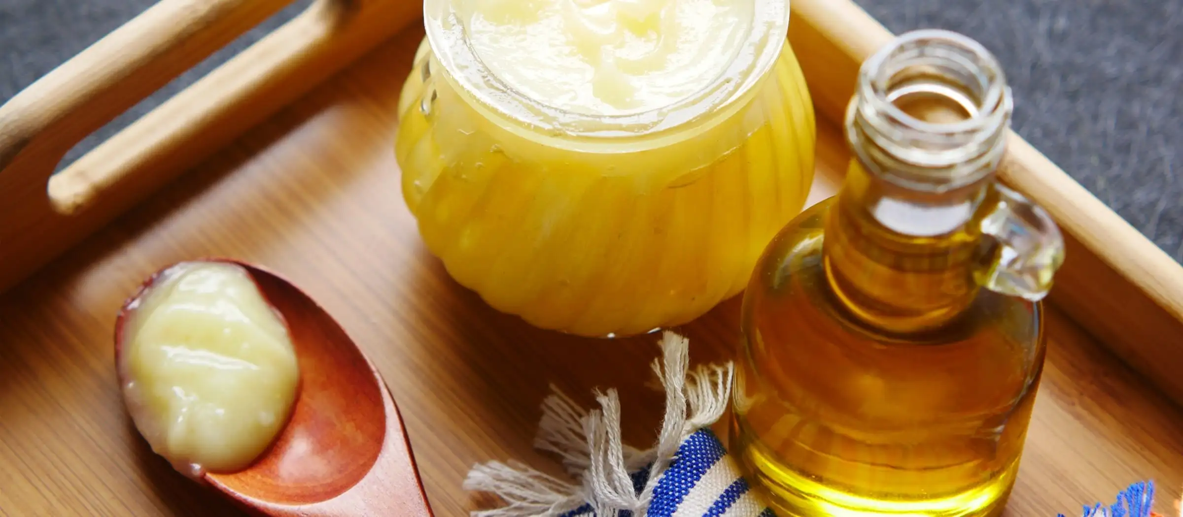 Glas mit geklärter Butter auf einem Tablett.