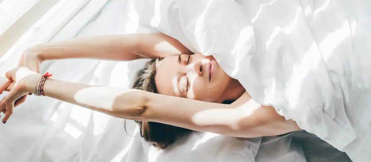 Eine Frau räkelt sich im Bett