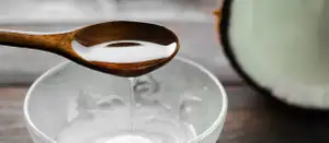 Kokosöl in einer Glasschüssel auf einem Tisch.