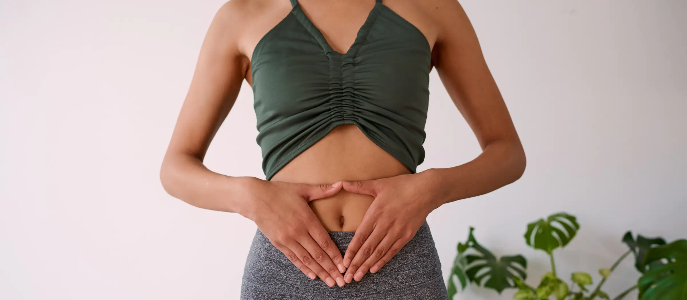 Frau legt die Hände auf ihren Bauch. 